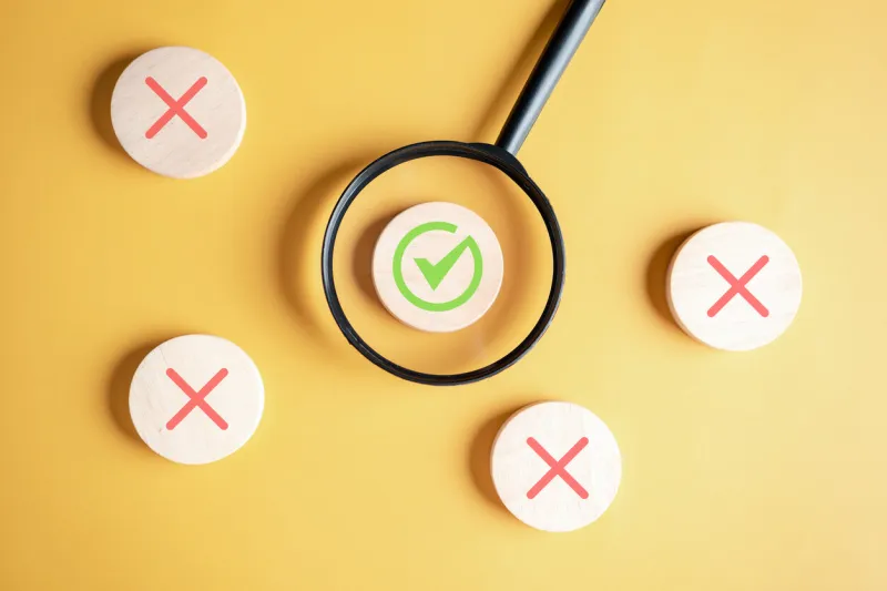 businessman holding magnifier focus to correct icon which among wrong icon on wooden block for document and project approve, check, mark