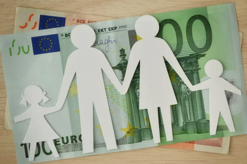 paper family cut-out on euro banknotes - family budget concept