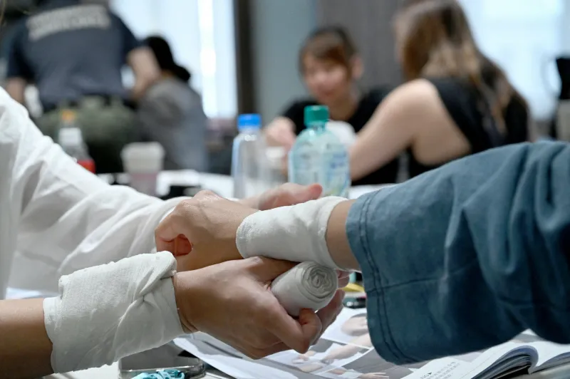 18 mai 2024, taiwan, taipeh   une femme fait un bandage autour du bras d'un participant lors d'un cours de défense civile à l'académie de kuma photo   johannes neudecker dpa abacapress   johannes neudecker dpa abacapresscom