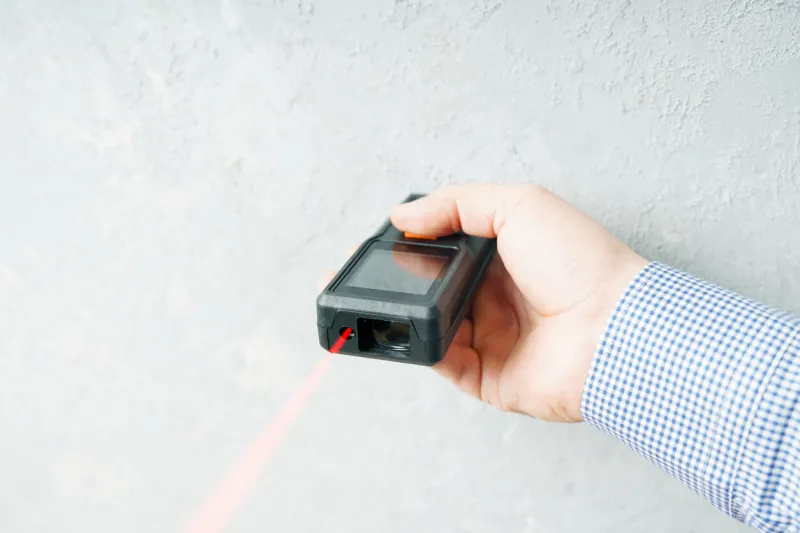 laser rangefinder or laser tape measure in a male hand it is a smart device for quick measurement of a distance