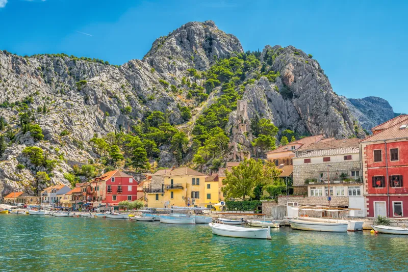 scenic view of the old city of omis in croatia with the adriatic sea and mountains with pine trees in the background