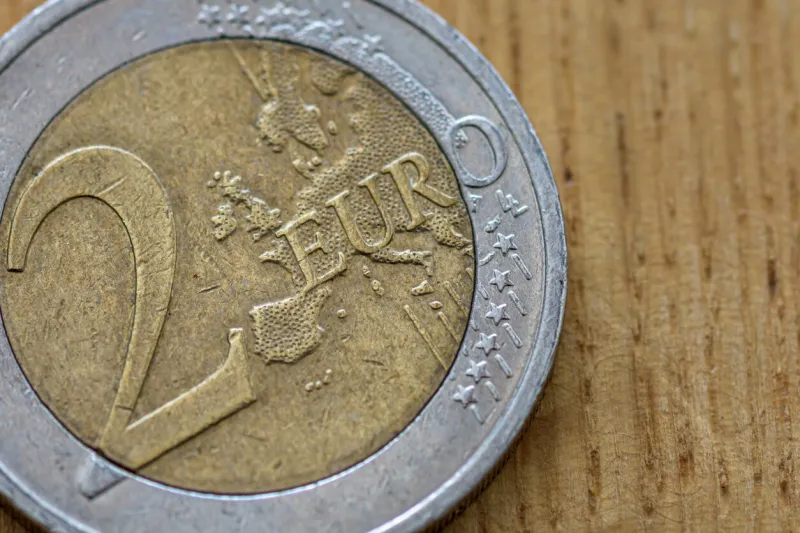 close up of 2 euro coin on wooden background, shallow depth of field, selective focus