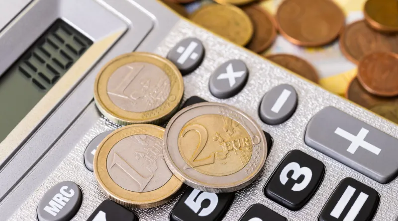 euro coins of various denominations and calculator