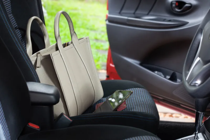 leather bag and phone on the car seat while the door is open