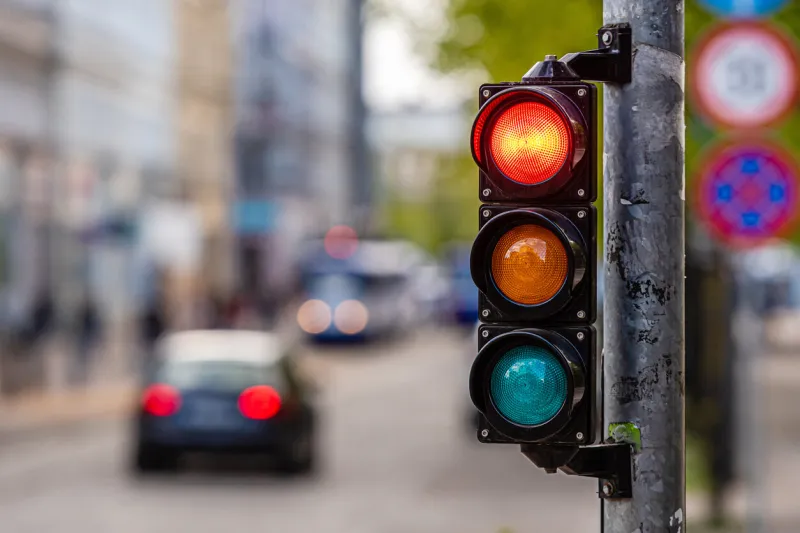 a city crossing with a semaphore, red light in semaphore, traffic control and regulation concept
