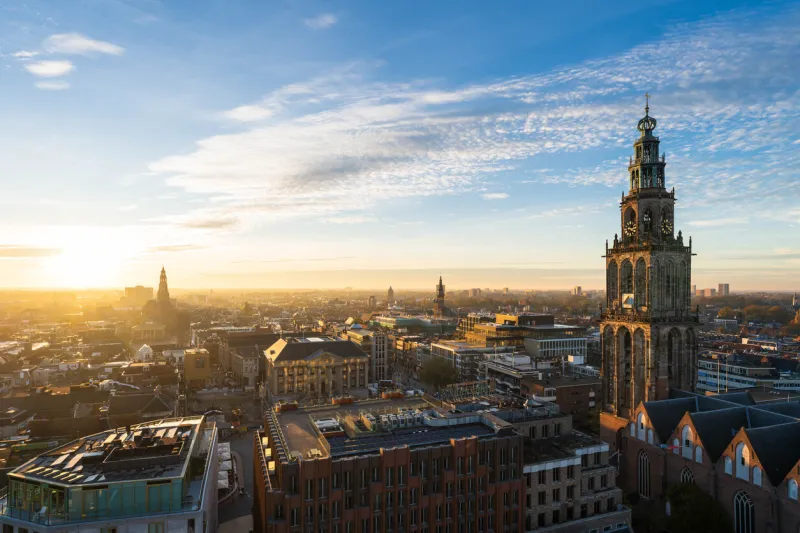 the sun setting over the historical city centre of groningen on a beautiful afternoon