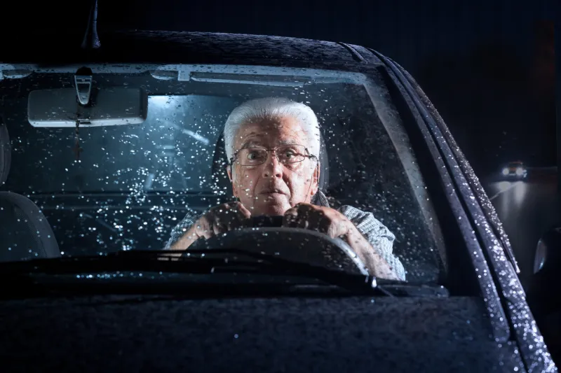 senior driving a car in the rain