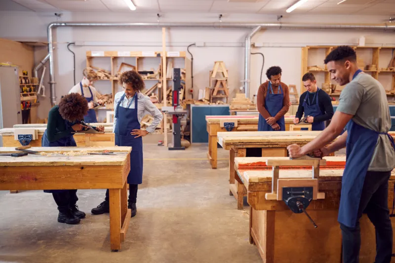 wide angle view of carpentry workshop with students studying for apprenticeship at college