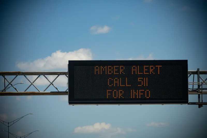 a digital sign above a busy highway alerts drivers to a current amber alert