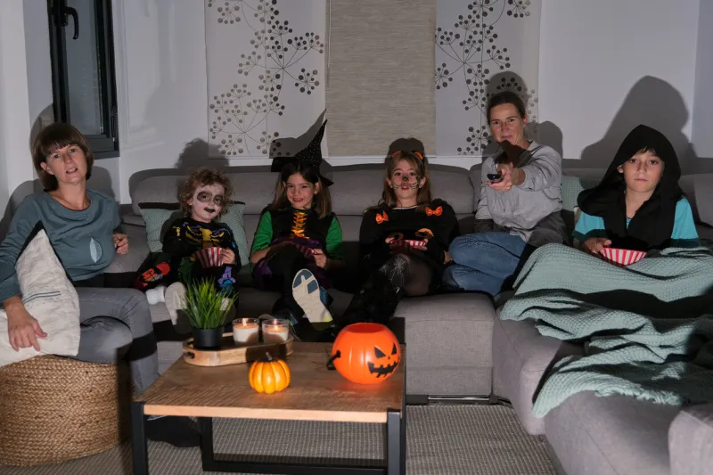 family and friends watching a horror movie on halloween halloween party