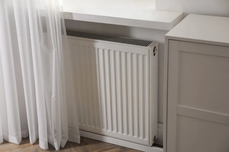 modern radiator on white wall near window indoors