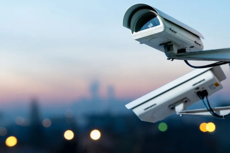 focus on security cctv camera monitoring system with panoramic view of a city on blurry background