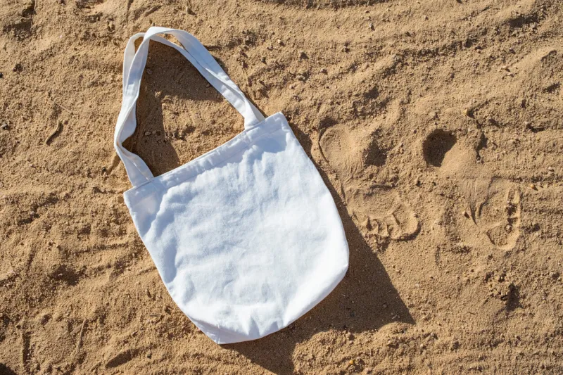 mockup shopper handbag, beach sand background top view copy space shopping eco reusable bag