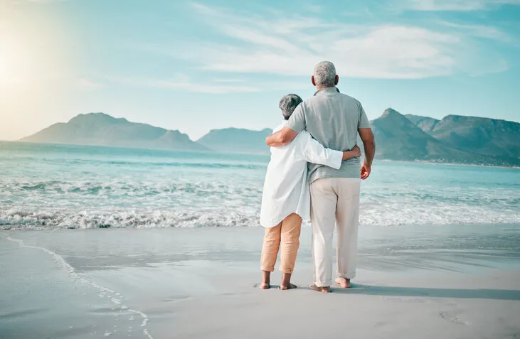 back, hug or old couple on beach to relax with love, care or support on summer vacation in nature retirement, mature man or senior woman at sea or ocean to travel on holiday together looking at view
