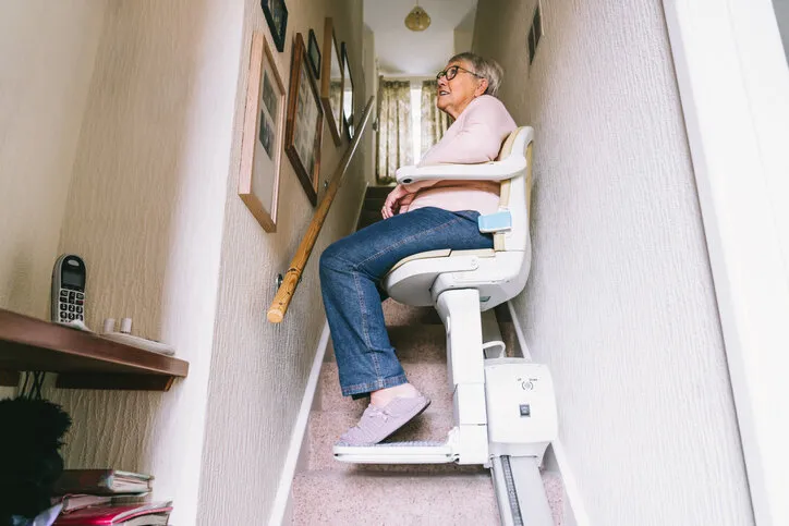 senior woman using automatic stair lift on a staircase at her home medical stairlift for disabled people and elderly people in the home selective focus