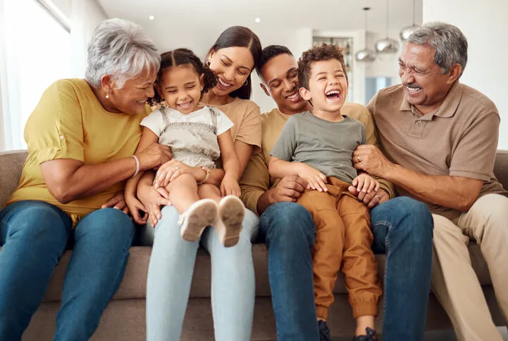 happy, big family and quality time bonding of children, parents and grandparents together on a sofa laughing kids having fun with mom, dad and grandparent on a home living room couch with happiness