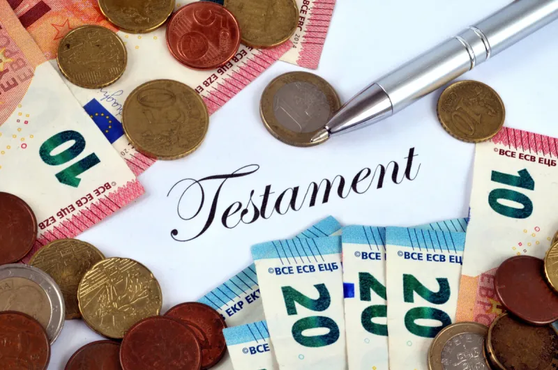 inheritance concept with banknotes and coins on an official document