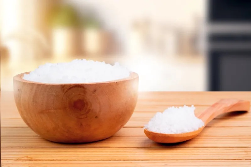 sea salt in a bowl and spoon wood with an opaque kitchen backdrop, sea salt is the salt produced by the evaporation of seawater product display