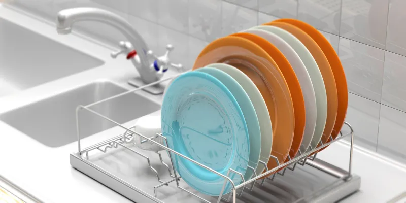 dish drying rack with colorful clean plates on a white kitchen sink counter 3d illustration