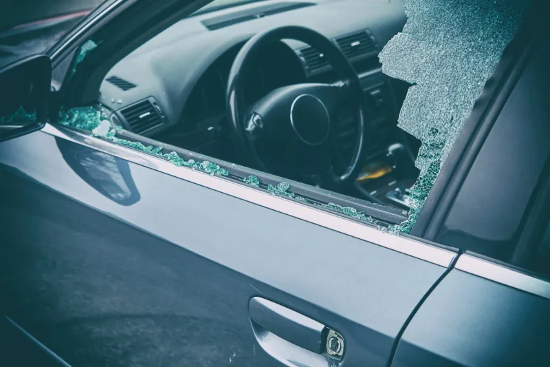 a criminal incident hacking the car broken left side window of a car