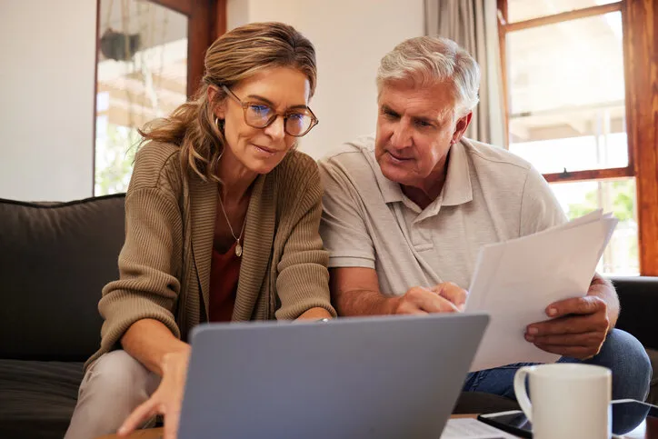 retirement couple budget, finance and investment planning, loan and paper bills with laptop technology in home mature people money, cash savings or legal insurance document report on online bank