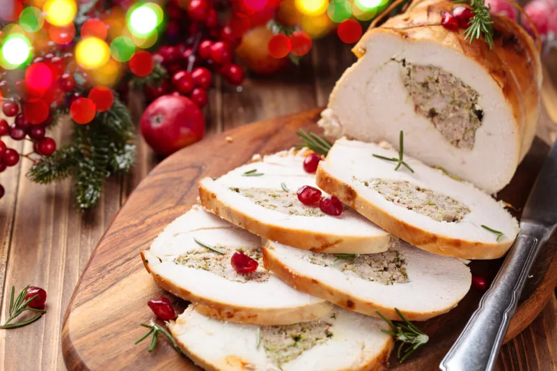 stuffed turkey breast with pomegranate and rosemary on cutting board