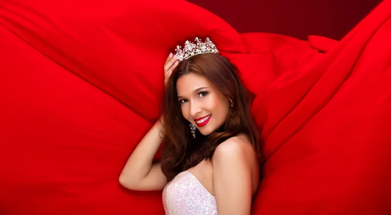 miss beauty queen pageant contest with diamond crown smile white teeth concept caucasian woman win prize, red tone background copy space