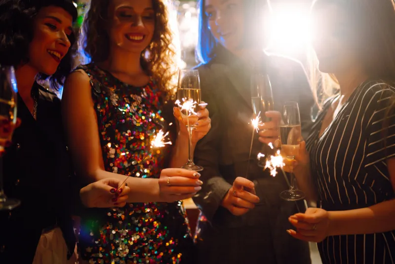 three young woman with champagne glasses at night club women friends drinking champagne in the bar