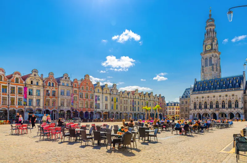 arras, france, july 3, 2023  hotel de ville town hall, townhouses buildings and street restaurant on heroes square in historical city center, artois, pas-de-calais department, hauts-de-france region