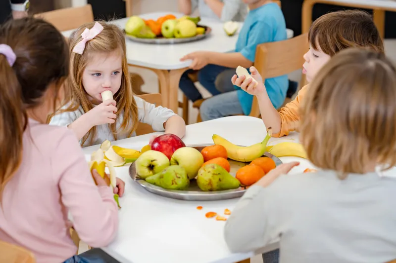 children eating a fruit snack in a kindergarten