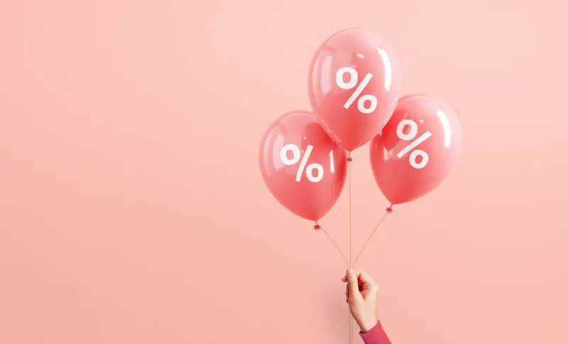 hand of woman holding pink balloons with percent on pink background, minimal, sale and discount copy space