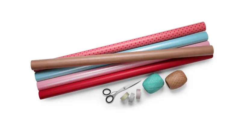 rolls of colorful wrapping paper, scissors and ribbons on white background, top view