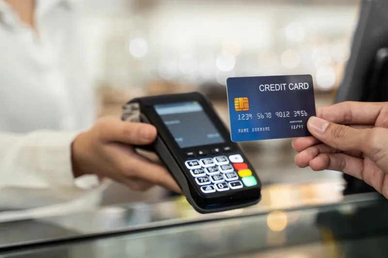 close up shot of customer hand using dummy credit card for payment to waitress at cashier in cafe restaurant, money cashless and credit card payment technology concept