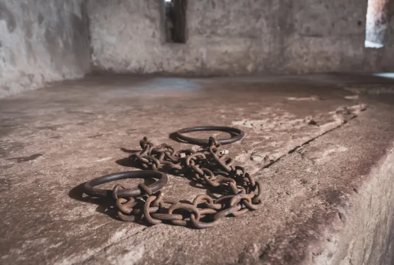 02 18 2022 - stone town, zanzibar  ancient handcuffs in slave cell cage for slaves african slave market interior of slave jail with rusty handcuffs humanity concept memorial of slave victims