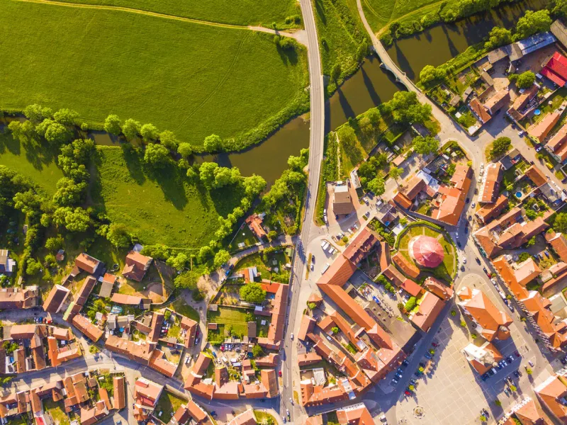 top down view of historical city centre near river and meadows town as background concept