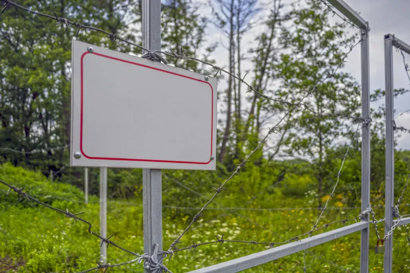 forbidden area fenced with a barbed wire fence gate with padlock closed to the key border of states