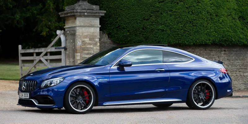 turvey, bedfordshire, uk - june 12th 2022 2019 mercedes c class amg c car driving through an english village
