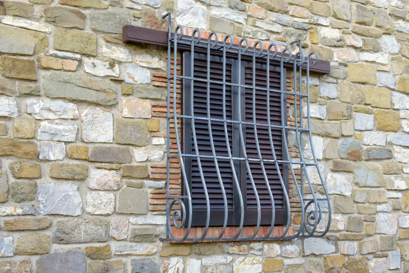 window with iron grating on stone wall