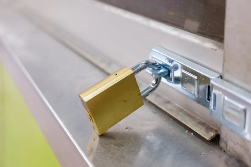 metal window frame with a brass padlock