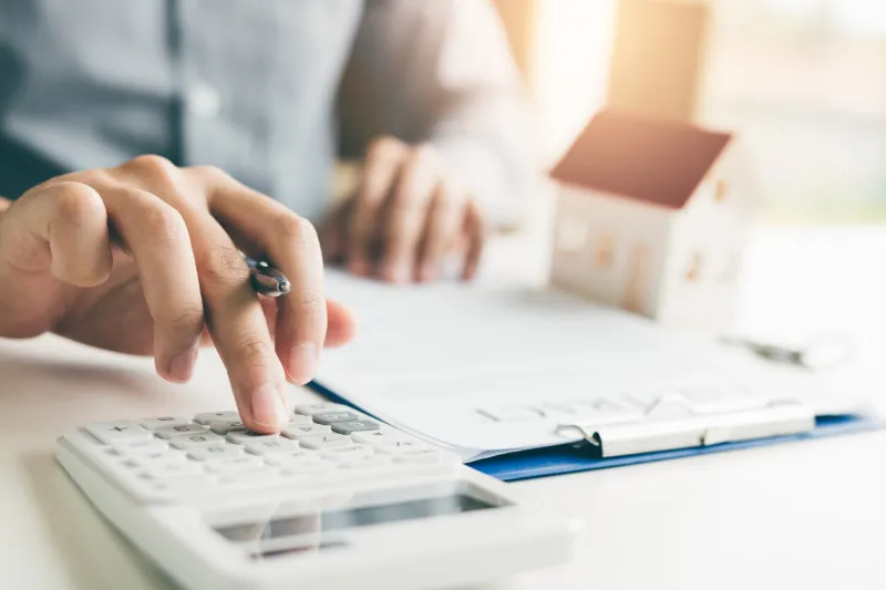 home agents are using a calculator to calculate the loan period each month for the customer