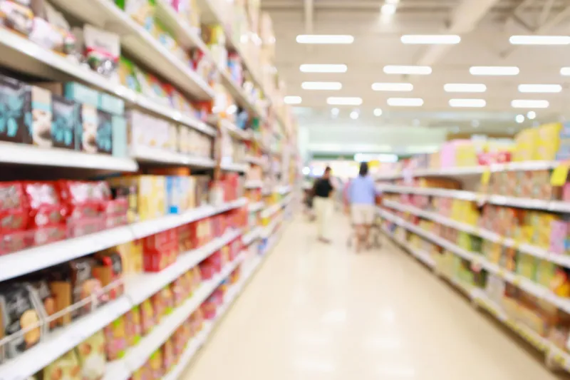 supermarket discount store aisle and product shelves interior abstract defocused blur background