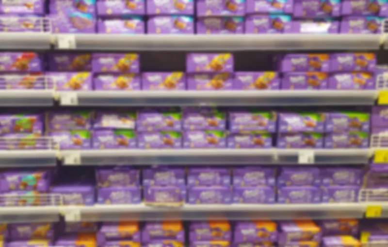 chocolate shelf in supermarket, blurred photo