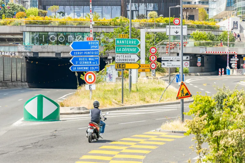 traffic signs at the entrance to the nanterre tunnel at la defense district in paris, france