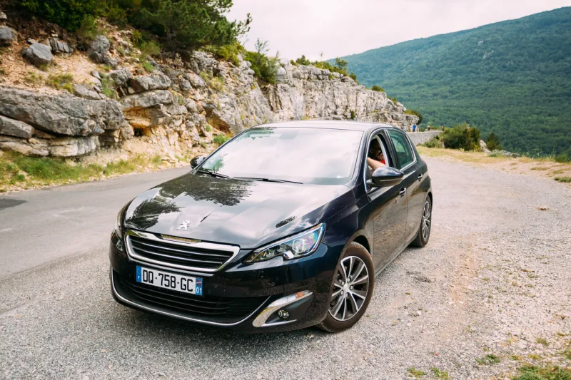 verdon, france - june 29, 2015  black colour peugeot 308 5-door car on background of french mountain nature landscape the peugeot 308 is a small family car produced by french car manufacturer peugeot
