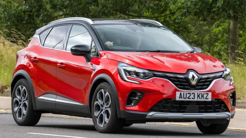 milton keynes,uk - july 2nd 2023 2023 red hybrid electric renault captur techno e-tech hev auto car travelling on an english country road