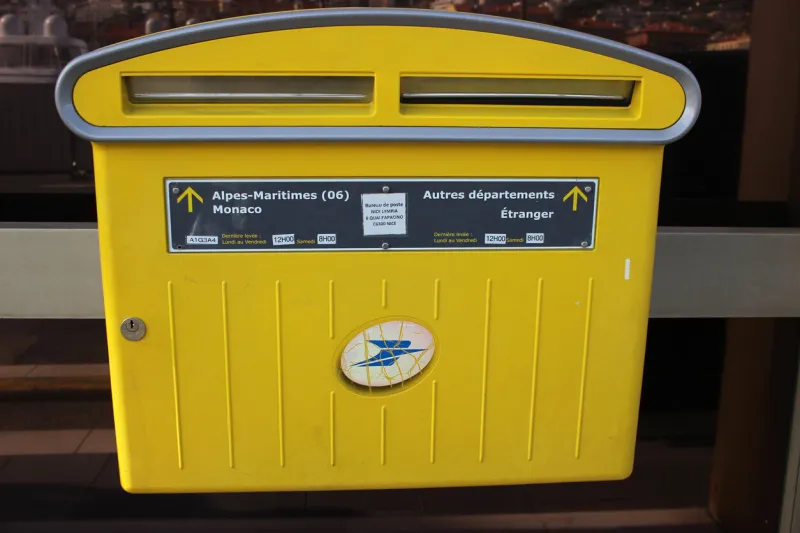 nice, france - february 15 2016  yellow official french mailbox a yellow modern postbox from la poste in nice, french riviera