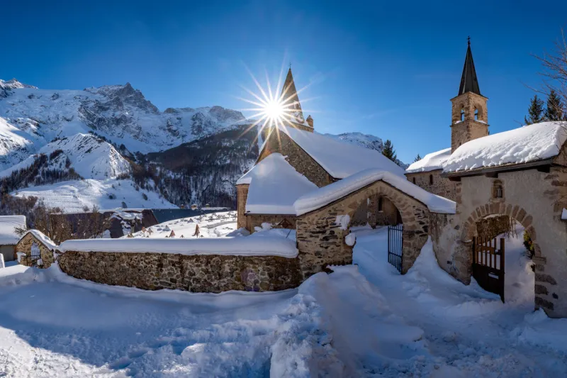 la grave, hautes-alpes, ecrins national park, alps, france  the local village of la grave and its church with la meije mountain peak in winter