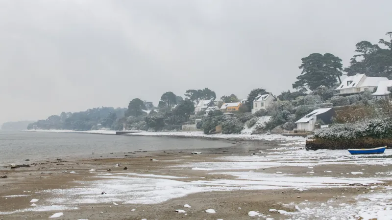 brittany, the ile aux moines, with a sailing boat in the harbor in winter, under the snow