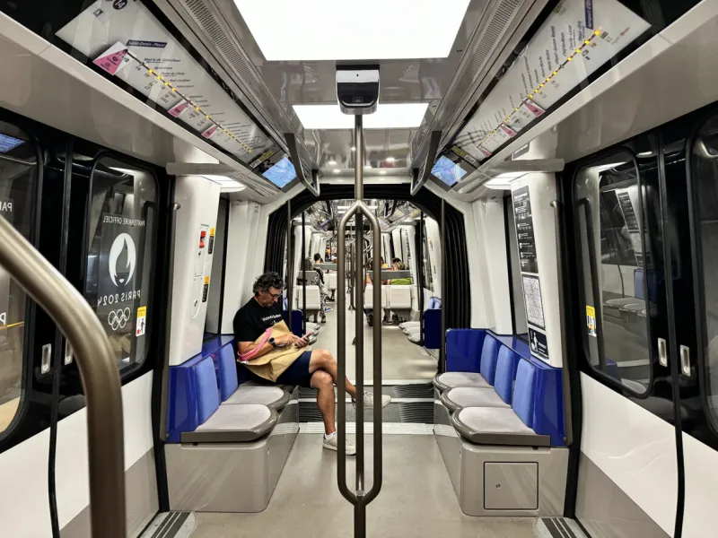 paris, france - august 7, 2024   interior view down the length of the new open gangway subway train with fabric seats on the driverless 14 line on the paris metro