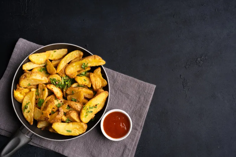 delicious potato wedges on the black background